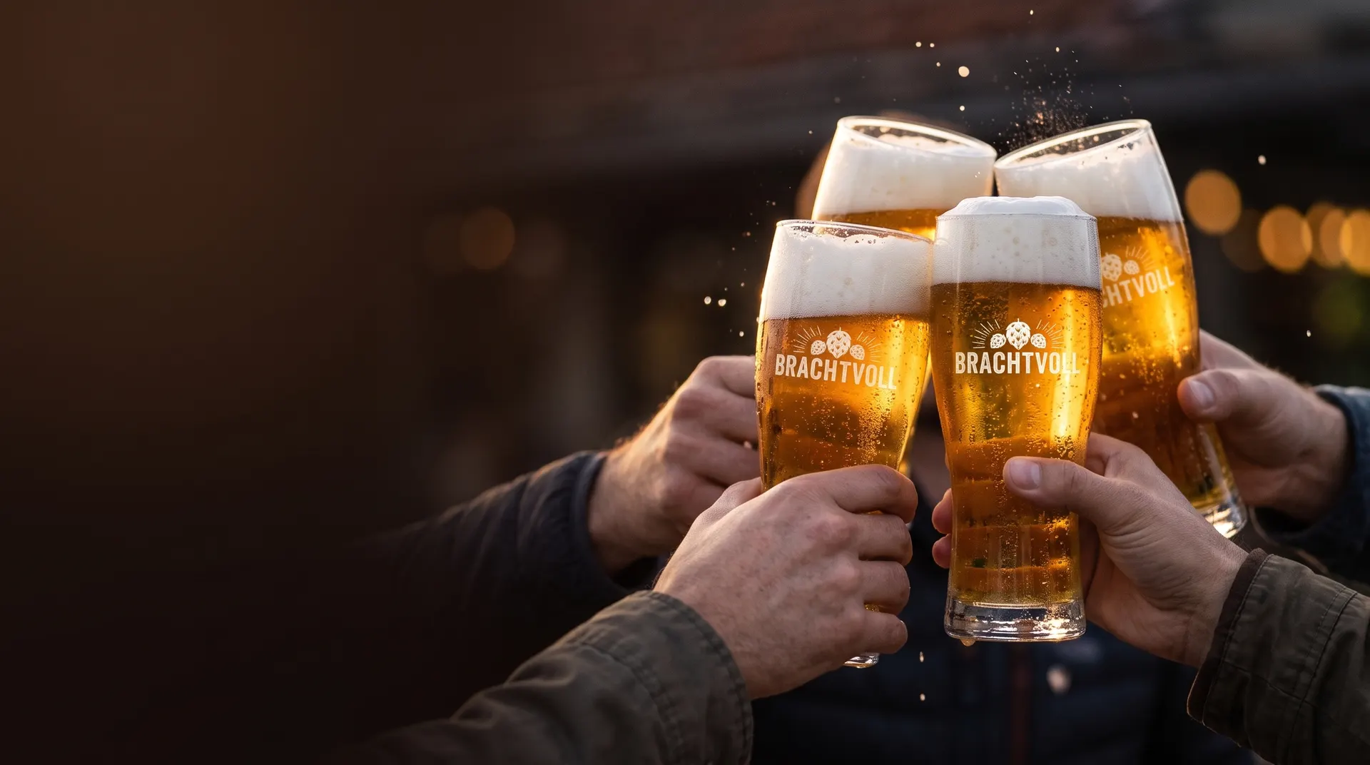 Vier Hände stoßen mit Brachtvoll-Biergläsern an